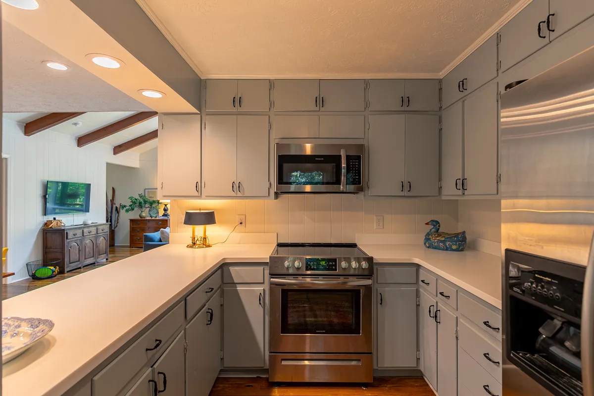 A chef-friendly kitchen featuring a stainless steel stove, gray cabinetry, a central kitchen island, and unique blue decorative touches. The setup encourages communal cooking and socializing, making it ideal for preparing group meals or snacks before adventures.